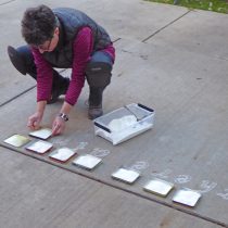 Jean laying down words using rice flour and homemade stencils